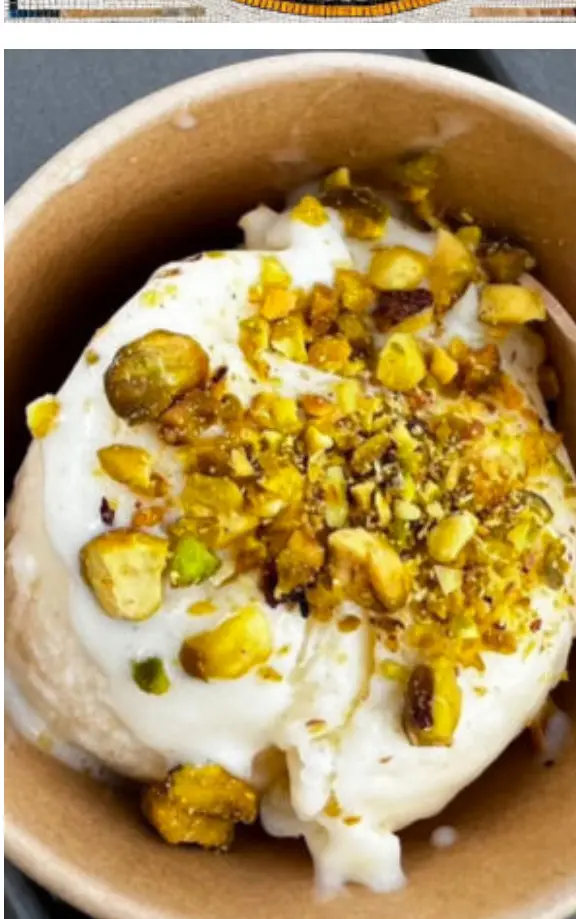 A cup of booza topped with crushed pistachios