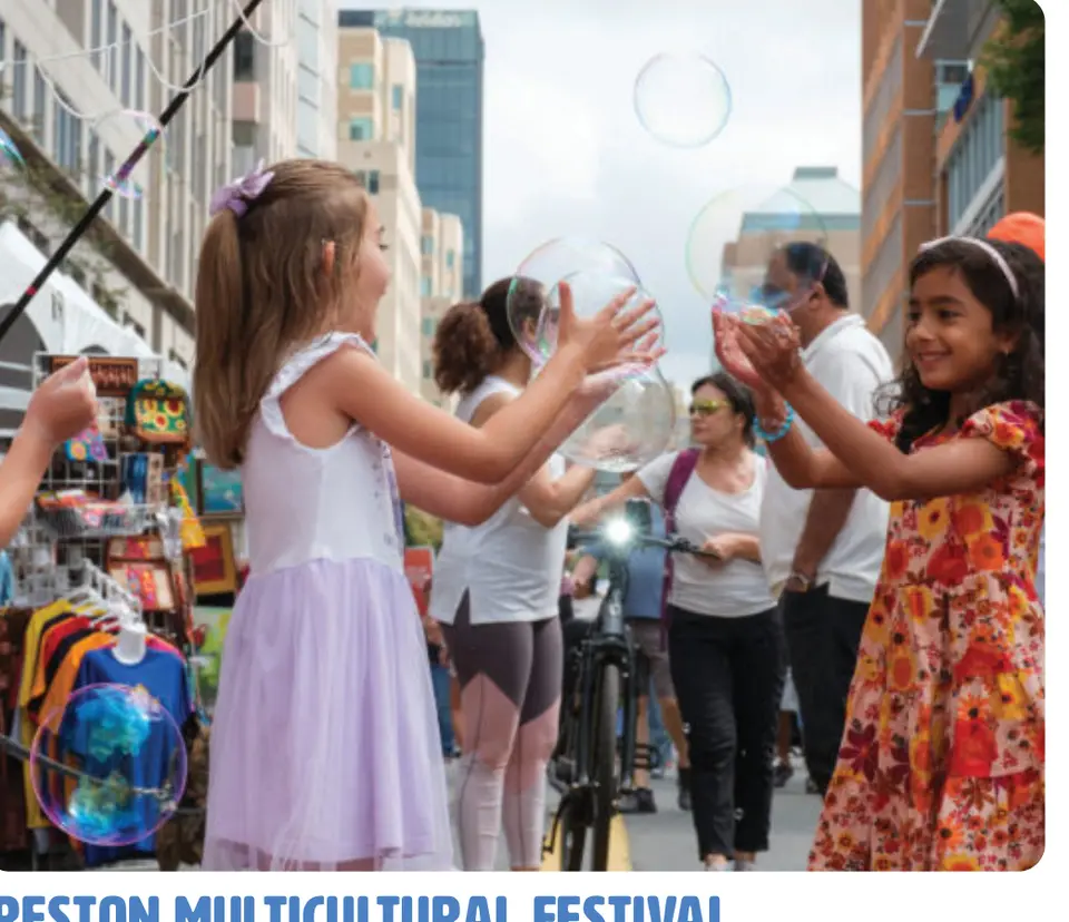 Children play with giant bubbles at a street festival