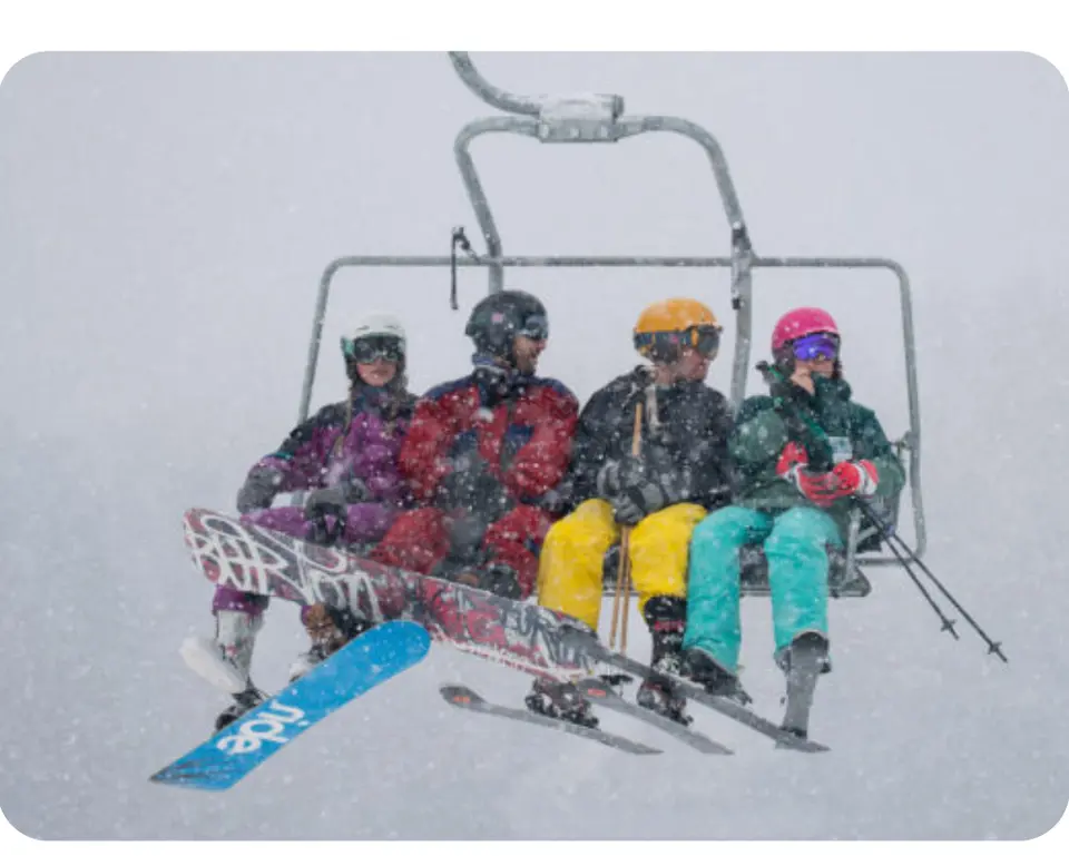 Snowboarders and skiers ride the chairlift.