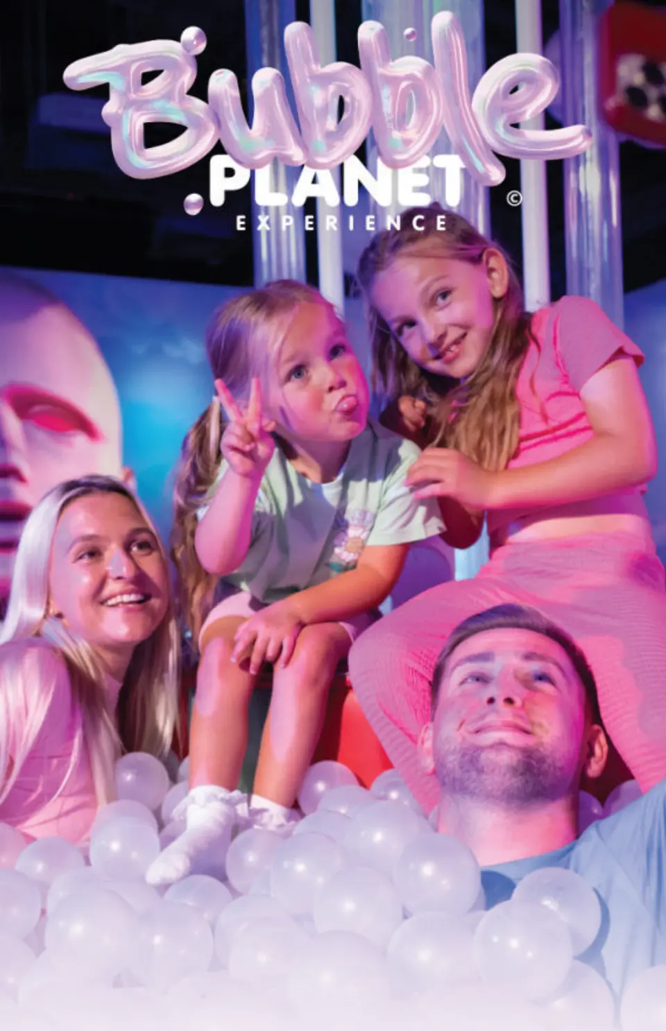 A family poses together in the ball pit.
