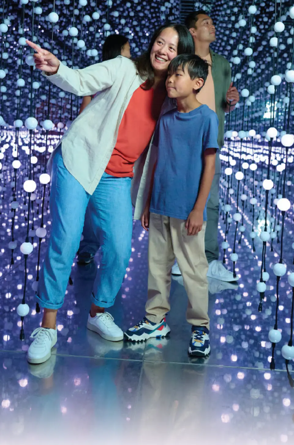 A family explores the glowing Infinity Room.