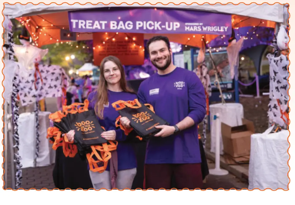 Staff hand out souvenir treat bags at the Treat Bag Pick-Up station.