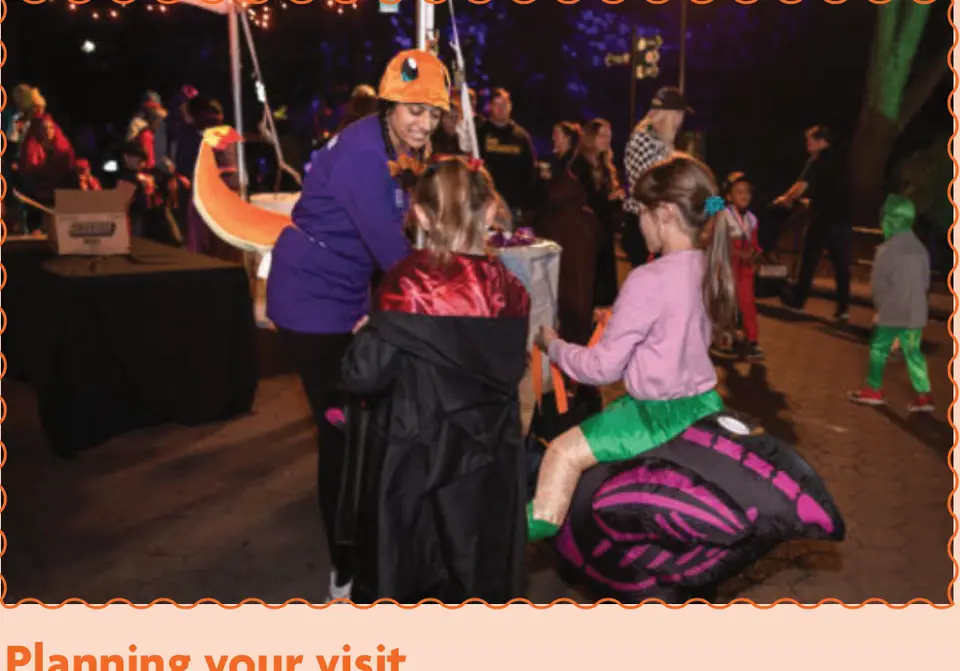 Families stop at a treat station after dark.