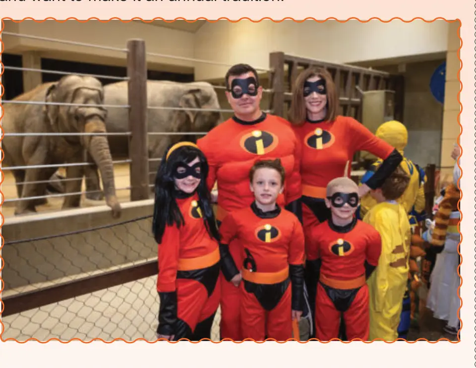 A family dressed as the Incredibles poses near the elephant habitat.